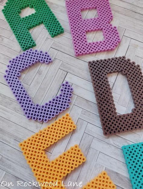 These perler bead letters can be used in an array of DIY projects as an embellishment, glue a magnet on the back, or string it up and use it as an ornament, gift tag or a garland - so many fun ways to use them! They are so quick and easy to make, and this DIY tutorial includes free patterns and video tutorials for all 26 letters. I like to use the 5 3/4″ pegboards that come with the puzzle piece edges so they can be interlocked. I keep them separated, but then am able to set 4 letters at a ti... Iron Beads Letters, Perler Bead Letters Alphabet, Letter A Perler Beads, Perler Letters, Perler Bead Alphabet, Perler Bead Letters, Perler Bead Letter Keychain, Bead Alphabet, Bead Letters