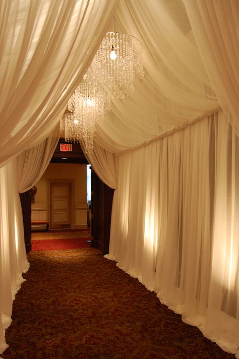 Custom Chiffon Grand Entrance  #fabricdrape #pipeanddrape #fabricswag #chiffon # entrancedecor #chandeliers #michiganweddings #colonialevents Draped Reception Hall, Wall Drapping Ideas, Tunnel Decoration Entrance, Gala Entrance, Prom Entrance, Prom Entrance Ideas, Wedding Tunnel Entrance, Wedding Tunnels, Decoration Buffet