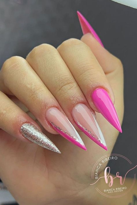 These stiletto nails offer a daring pop of style with their bold design. A vibrant neon pink commands attention on a standout nail, while glittering silver on another nail adds a dash of sparkle. The remaining nails feature a nude base with neon pink accents and silver glitter lines that give an elegant yet edgy vibe. Perfect for making a statement at any event.✨  // Photo Credit: Instagram @studiobiancaribeiro_ Silver And Pink Nails, Acrylic Nails Yellow, Pink Stiletto Nails, Red Stiletto Nails, Stiletto Shaped Nails, Vday Nails, Pink Glitter Nails, Beauty Nails Design, Acrylic Nails Coffin Short