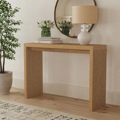 The Jasper minimalist console table with a waterfall edge design makes a one-of-a-kind statement piece for your living space. The sleek rectangular table is hand finished in timeless black or light natural wood stain. The angular, clean lines of the console's silhouette has tapered detailing making a feature of the fine craftsmanship and organic wood tones. The versatile style of this console is at home in modern, industrial and transitional living rooms, dining rooms or entryways. Color: Brown Wayfair Console Table, Console Table Wood Modern, Light Wood Console Table, Tall Console Table, Diy Modern Console Table, Waterfall Console Table, Entrance Table Ideas, Natural Wood Console Table, Minimalist Console Table