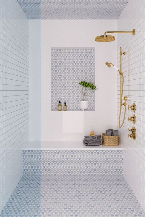 a coastal shower space done with white and blue tiles, a niche, a bench, some towels and gold fixtures Interior Shower Design, Cappuccino Marble Bathroom, Cottage Modern Bathroom, Bathrooms With Color, Lakehouse Bathroom, Parents Bathroom, Beach Bathroom Decor, Bad Inspiration, Hawaii Homes