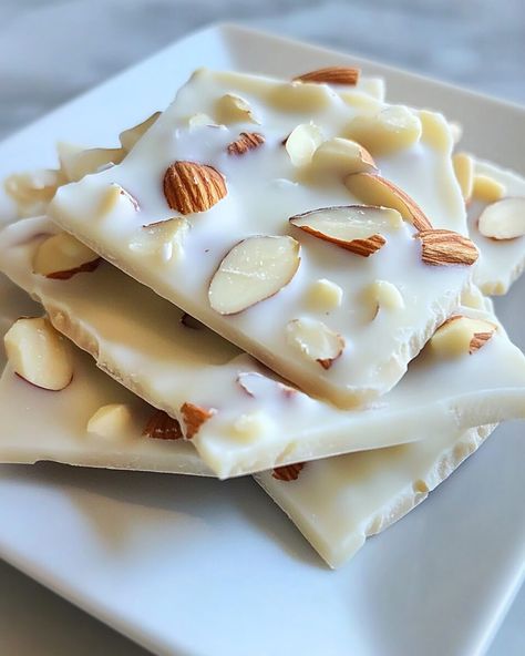 If you’re looking for a quick and delightful treat, this White Chocolate Almond Bark is sure to impress. With only four ingredients, it combines creamy white chocolate with the nutty crunch of roasted almonds for a perfectly balanced bite. The addition of a hint of vanilla elevates its sweetness, making […] White Chocolate Squares, White Chocolate Almond Bark Recipes, Puff Corn White Chocolate Almond Bark, Almond Bark Recipes Easy, White Bark Candy, White Chocolate Treats, Almond Bark Candy, Pecan Bark Recipe, White Chocolate Almond Bark