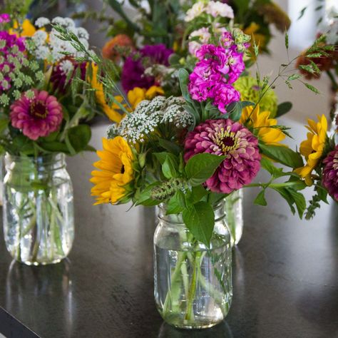 If you love the beauty that only fresh flowers can bring and are seeking an economical way to make small floral bouquets a bucket of blooms may be the perfect option. If you think you lack creativity, don't be intimidated! This step-by-step tutorial will demonstrate how to turn our bucket of blooms into ten mini mason jar bouquets. Farm Floral Arrangements, Zinnia Bouquet Mason Jars, Small Floral Arrangements Simple, Farmers Market Flowers Bouquets, Bouquet Making Party, Farmers Market Bouquet, Simple Flower Arrangements, Market Bouquets, Small Floral Arrangements