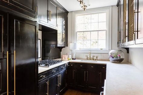 Small black contemporary u-shaped kitchen features glossy black cabinets accented with brass hardware and a white quartz countertop . Black Shaker Kitchen Cabinets, Black Shaker Kitchen, Mirrored Kitchen Cabinet, White Tile Kitchen Floor, White Tile Kitchen Backsplash, Brass Kitchen Hardware, White Shaker Kitchen Cabinets, White Kitchen Tiles, Small Kitchen Cabinets