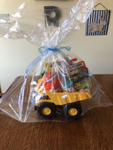 Toddler boy gift basket. Dump truck filled with toys, cars, cookies, play doh, and lollipops. Clear gift bag from dollar tree tied with a ribbon. Toddler Gift Basket, Cars Cookies, Cadeau Man, Toy Gift Basket, Boy Gift Basket, Theme Baskets, Dollar Tree Gifts, Clear Gift Bags, Christmas Gift Baskets Diy