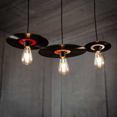 Elevate your space with a nostalgic touch and stylish ambiance by investing in our Retro Vinyl Record Lamp Pendant Set in a sleek black finish. Crafted from upcycled vinyl records, each lamp within the set is a unique piece of art, ensuring a distinct character for your lighting arrangement. 🎵💡 Available in versatile sets: - Set of 3 in 7-inch single size - Set of 3 in 10-inch EP size - Set of 3 in 12-inch LP size - Mix and match with a set featuring one of each size Handcrafted from authentic upcycled vinyl records, each lamp boasts individuality and may exhibit a variety of colors due to the upcycling process. The elegant black finish provides a modern and timeless aesthetic that complements various interior styles. Bulbs not included, offering you the flexibility to tailor the lightin Vinyl Record Ceiling, Custom Lighting Design, Record Upcycle Diy, Unique House Furniture, Retro Lamps Vintage, Record Lamp, Artistic Lamps, Alternative Lighting, Vinyl Record Projects