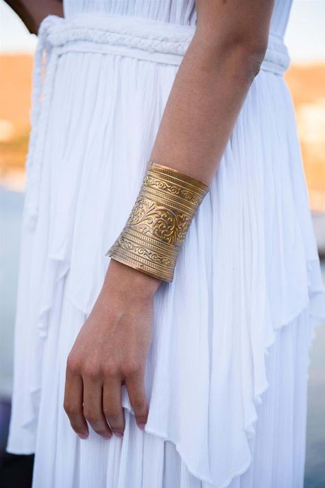 Gold cuff bracelet and a grecian gown for the Greek Goddess performer at the luxury anniversary reception in Mykonos | Mykonos Wedding Planner & Designer: @mitheoevents Photo: @mindartphotography Venue: @kivotoshotel | #mitheoevents #weddingplannergreece #mykonosweddingplanner #destinationweddinggreece #mykonoswedding #mykonosanniversary #weddingreception #weddingparty #grecianwedding #ancientgreece #weddingdecor #weddingstyling #grecianstyle #grecianoutfit #grecianweddingdress Grecian Outfit, Greek Fashion Modern, Ancient Pillars, Ancient Greece Architecture, Greece Theme, Greek Wedding Theme, Ancient Greek Bracelet, Diana Artemis, Island Scenery