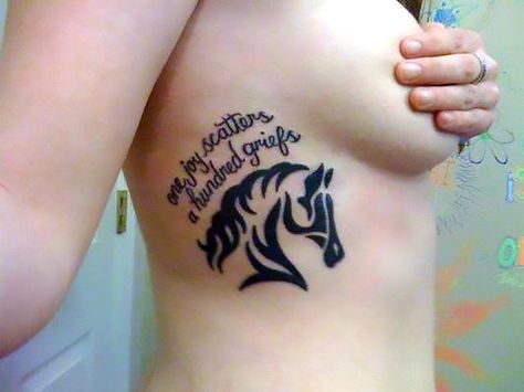 A tattoo with a head of a tribal horse and inspiring text on the side of the wearer. Quote: "One joy scatters a hundred griefs". Equine Tattoo, Horses Quotes, Tattoos On Side Ribs, Horse Shoe Tattoo, Horse Tattoo Design, Quotes Tattoos, Horse Tattoo, Side Tattoos, Head Tattoos