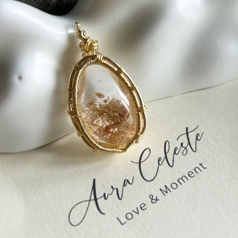 This one-of-a-kind pendant features a mesmerizing Phantom Quartz, known for its crystal-clear transparency and captivating natural inclusions. The gentle yet majestic hues within the stone create an ethereal landscape, sculpted by nature’s artistry over time—a breathtaking display of depth and elegance.

The delicate handcrafted wire wrapping enhances the pendant’s beauty, adding a touch of sophistication while ensuring that its natural charm remains the focal point. Whether worn as a chic everyday necklace or paired with a cozy sweater for an elevated look, this versatile pendant complements a variety of styles and occasions.