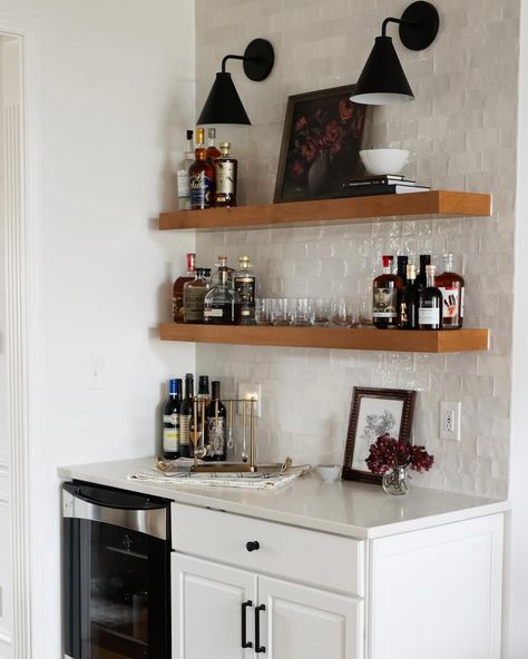 Instead of tearing out the entire bar of our Ravenna I kitchen, we decided to salvage and paint a portion of the cabinetry, add floating shelves, a tile backsplash and sconces above. We removed the element that was really making the space feel dated…the angled wall, and replaced the rest of the cabinetry with a freestanding hutch. Is it easier to just tear everything out and start from scratch? 100% yes. Is it more rewarding to find creative solutions to challenges, while keeping what we can?... Floating Shelves With Tile Backsplash, Sconces Above Floating Shelves, Floating Shelves With Sconces, Floating Shelves Above Bar, Shelf Backsplash, Angled Wall, Oven Hood, Floating Shelves Kitchen, Mirror Backsplash