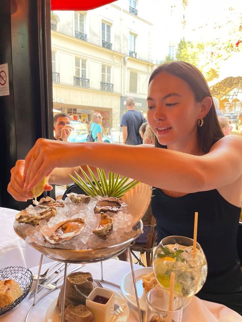 Action shot/ candid of girl eating oysters. On vacation, casual, nice outfit. The display looks amazing and the setting is lively. Drinks on board and lemon on hand. Oysters At Party, Aesthetic Oyster, Oyster Bar Aesthetic, Oyster Restaurant, Eating Oysters, Oyster Bar, Project Photo, Picture Poses, Seafood