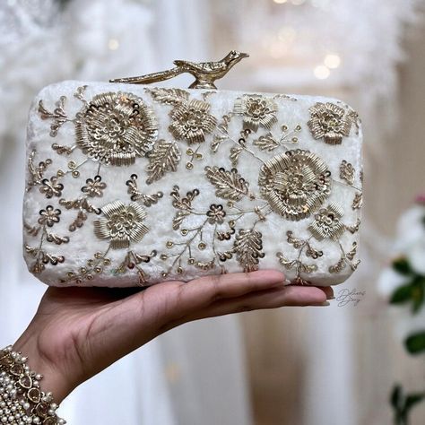 Introducing our Box Clutch with Hand-Embroidered Zardozi Work--a perfect blend of opulence and craftsmanship. Immerse yourself in the luxury of premium quality as we present a meticulously designed accessory that stands out from the rest. Crafted with a premium quality frame and adorned with hand-embroidered Zardozi work, this clutch is a testament to the artistry and attention to detail that sets it apart. The lavish velvet material adds a touch of sophistication, ensuring you carry an accessory that exudes elegance. Open the clutch to reveal a sumptuous suede fabric lining, providing a soft and luxurious interior. We've considered your practical needs with a small pocket designed to securely hold your credit card or ID, adding convenience to style. Completing the ensemble is a thick, hig Embroidered Clutch Bag, Handmade Wristlet, Zardozi Embroidery, Velvet Clutch, Embroidered Clutch, White Clutch, Suede Handbags, Wedding Purse, Box Clutch