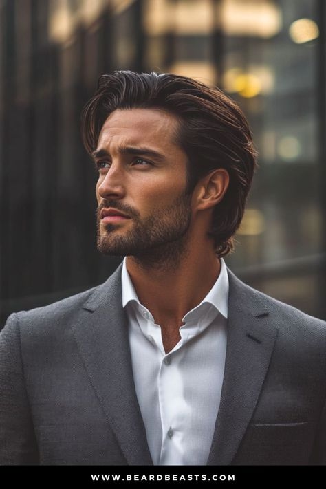 Man with long, slicked-back hair and a neatly trimmed beard, wearing a tailored suit, exuding a polished and professional look. The slicked-back style emphasizes a sharp and clean aesthetic, making it an ideal example of men's hairstyles for long hair that blend sophistication with modern charm. Men’s Haircuts Long Hair, Wavy Men’s Hair, Mens Hairstyles For Long Faces, Haircut Short On Sides Long On Top, Men S Hairstyle Long, Gentlemen’s Haircut, Long Ish Hair Men, Mens Modern Haircut, Mens Brushed Back Hairstyles