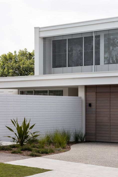 The white stack bond brick fence sets the aesthetic tone from the street facade, an appropriate backdrop to the row of palm trees that greets visitors on arrival and suggests a holiday feeling within the home beyond. #Architecture #Fence #Brick Stack Bond Brick, Timber Garage Door, Timber Garage, Midcentury Modern Style, Brick Fence, Mid Century Architecture, The Local Project, The Palms, White Brick