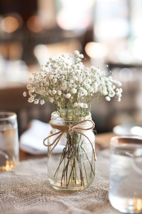 Bring a classic, personalized touch to your wedding with floral centerpieces. Click here for more inspiration. Rustic Jars Wedding, Mason Jar Decorations For Weddings, Simple Flowers Wedding Table, Flowerless Centerpieces Wedding, Minimalist Floral Centerpieces, Easy Mason Jar Centerpieces, Simple Wedding Centerpieces Diy Budget, Simple Mason Jar Centerpieces, Diy Wedding Centerpieces On A Budget