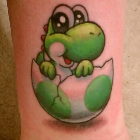 My baby yoshi tattoo by matt brumelow who does fantastic video game tattoos Small Yoshi Tattoo, Yoshi Tattoos, Yoshi Tattoo, Yoshi Drawing, Super Mario Tattoo, Pokemon Tattoos, Pokemon World, Mario Tattoo, Underboob Tattoo Designs