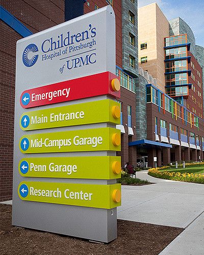 Exterior signs extend the same toy-like, plug-and-play design vocabulary outside the building and provide continuity of the wayfinding experience for visitors. As with interior signs, colors and materials were carefully coordinated with the building architecture. Design Vocabulary, Hospital Signage, Pylon Signage, Business Signs Outdoor, Entrance Signage, Direction Sign, Hospital Signs, Wayfinding Signage Design, Signage Signs