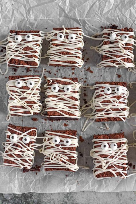 Use a delicious fudgy brownie recipe, frosting, and candy eyes to make these adorable Halloween Brownies in the shape of a mummy! These are perfect for a festive, tasty, and fun dessert for your Halloween celebration. Halloween Brownies Spooky, Brownie Graveyard, Brownie Halloween, Halloween Brownie Mummies, Ghost Brownies, Mummy Brownies, Cobweb Brownies, Halloween Brownie, Halloween Brownies