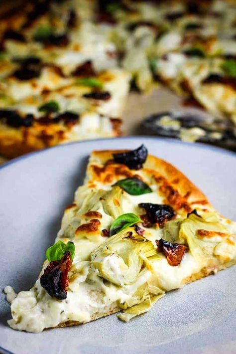 Artichokes have the starring role in this pizza, which also features a creamy herb and garlic Boursin cheese sauce, tangy sun dried tomatoes, and fresh mozzarella. This is truly the best artichoke pizza recipe. #pizza #artichokes #dinner Mediteranian Pizza Recipes, Boursin Cheese Pizza, Pizza With Artichokes, Sun Dried Tomato Pizza Recipes, Meat Flatbread Recipes, Unique Italian Dinner Recipes, Boursin Cheese Sandwich Recipes, Boursin Pizza, Recipes Using Boursin Cheese