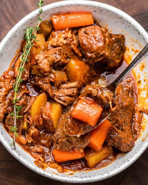 Guinness beef stew is a hearty dish that's perfect for cold weather, and especially on St. Paddy's Day. Chunks of beef, carrots, celery, and potatoes are braised in a mixture of Guinness, beef stock, and fresh thyme, and best served with crusty bread. #guinnessbeefstew #irishbeefstew #irishrecipes Irish Stew Recipe, Simmering Pot, Guinness Beef Stew, Beef And Potato Stew, Irish Beef Stew, Hearty Stew, Coconut Curry Soup, Irish Stew, Irish Food