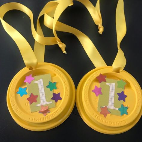 Painted plastic coffee cup lids can be decorated and made into kids' award medals. Run a ribbon through the opening and let the competition begin. Coffee Cup Lid Crafts, Diy Medals For Kids, Gold Medal Craft, Diy Medals, Olympic Medal Craft, Medal Craft, Olympic Gold Medal Craft, Plastic Coffee Cup, Trophy Craft