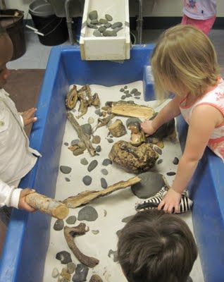 sticks and stones sensory table. This one was so meant for me! I might add fossils to mine :) Sand Tray Ideas Eyfs, Rocks In Water, Natural Playground Ideas, Sensory Tubs, Sand Tray, Playground Ideas, Eyfs Activities, Sensory Activities Toddlers, Water Tables