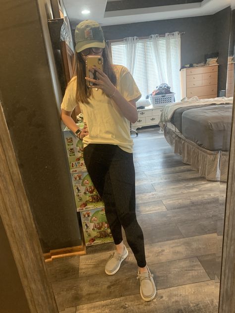 A yellow t shirt with black leggings and a sage green hat with grey hey dudes Hey Dude Work Outfit, Hey Dudes And Leggings, Cute Outfits With Hey Dudes, Western Outfit With Leggings, Grey Hey Dudes Outfit, Leggings And Hey Dudes Outfit, What To Wear With Hey Dudes, Western Fits With Leggings, Hey Dude Outfits