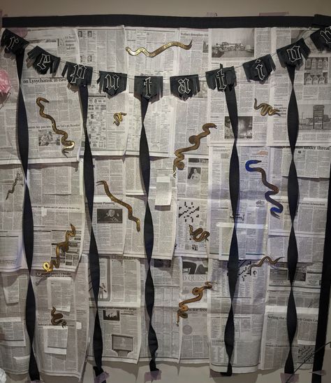 A photo backdrop is taped to a wall. It consists of pieces of layered black and white newspaper adorned with golden paper snakes. Across the top of the wall, a black banner reads "Reputation" in the font used on Taylor Swift's Reputation album. Black twisted streamers emerge from behind the letters, reaching to the bottom of the newspaper. Taylor Swift Birthday Party Reputation, Taylor Swift Reputation Bachelorette, Taylor Swift Birthday Reputation, Reputation Taylor Swift Themed Party, Taylor Swift Reputation Bachelorette Party, Taylor Swift Themed Birthday Party Reputation, Reputation Taylor Swift Party Theme, Taylor Swift Reputation Party Ideas, Taylor Swift Inspired Cake Reputation