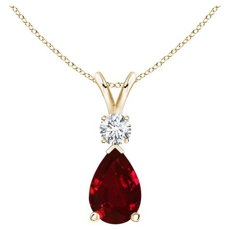 This classic solitaire pendant features a pear-shaped ruby secured in a prong setting. A brilliant round diamond sits atop the purplish red gemstone. Simple yet alluring, this ruby pendant in 14k yellow gold is crafted with a lustrous v-bale. Ruby - Heat treated for enhanced clarity and brightness.Diamond - Not-treated.Diamond Information:Diamond Color: GClarity: VSShape: RoundCreation Method: NaturalTotal Diamond Weight: 0.105Total Number of Diamond: 1 Ruby Diamond Pendant, Platinum Chain, Ruby Birthstone, Platinum Rose Gold, Bracelet Love, Ruby Pendant, Rose Gold Chain, Red Gemstones, Ruby Jewelry