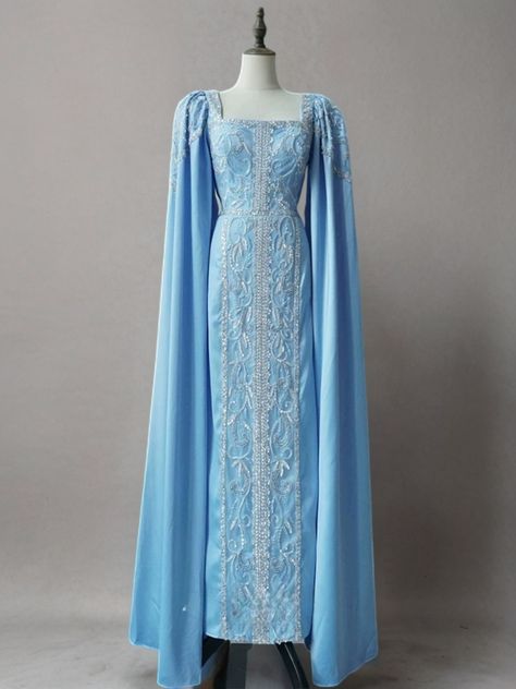 Step into sophistication with the Light Blue Beaded Formal Dress with Cape Sleeves. This elegant evening gown is adorned with intricate beadwork and pretty sequins that catch the light, adding a dazzling touch to your look. The unique cape sleeves drape gracefully, creating a regal and timeless silhouette. The fitted bodice, featuring exquisite beaded details, enhances the luxurious appeal of the dress. The square neckline adds a classic and refined touch, while the full-length design ensures you make a memorable entrance at any formal event. Perfect for those who seek a blend of elegance and grandeur, this gown provides a flattering fit that accentuates your curves and offers all-night comfort. Shine brightly in this stunning light blue beaded gown and create unforgettable moments. Light Blue Fitted Dress, Blue Gowns Elegant, Blue Dress With Cape, Snowflake Gown, Formal Dress With Cape, Evening Gown Plus Size, Elvish Dress, Dress With Cape Sleeves, Royal Gowns