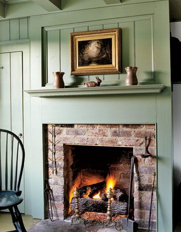 A sage green raised panel wall reveals a simple brick fireplace in this early-19th-century home. Antique pottery is displayed on the mantel. Country Fireplace, Cottage Fireplace, Mantel Ideas, Casas Coloniales, Colonial Decor, Home Fireplace, Fireplace Makeover, Cozy Fireplace, Brick Fireplace