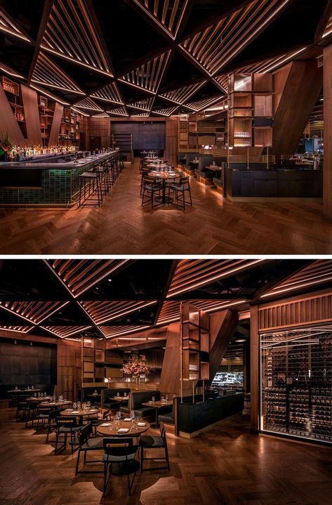 This modern restaurant's distinctive and massive structural joists divide the bar area from the main dining room. These angled columns& inspired the bar’s geometrical millwork and its triangular patterned wood trellis ceiling. #RestaurantDesign #ModernRestaurant #RestaurantInterior Bar Ceiling Lights, Pub Ceiling Design, Celing Roof Design For Restaurant, Triangular Ceiling Design, Back Bar Design Restaurant Modern, Restaurant Ceiling Design Modern, Bar Ceiling Design, Restaurant Ceiling Design, Trellis Ceiling