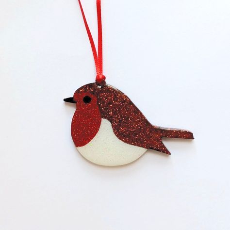 A simply gorgeous and sparkly handmade robin ornament for hanging on your tree this Christmas. Made with Brown, Red and white glitter and resin.  Measurements - Total height 4.5cm                               Total width - beak to tail - 7.5cm approx A smaller version is available here https://www.etsy.com/uk/listing/1328659999/handmade-small-glitter-robin-christmas Materials - Resin, Glitter. If you require more than what is available in stock, please do not hesitate to contact us. Due to small parts, this product is not suitable for children. We currently do not ship to Germany. Additional Information Although every care and effort has been made to make sure that the item you receive is the same as in the pictures listed, the resin sections of my jewellery are handmade and therefore may Robin Ornament, Burlap Christmas Decorations, Robin Christmas, Resin Glitter, Christmas Material, Burlap Christmas, Christmas Tree Decoration, White Glitter, Tree Decoration