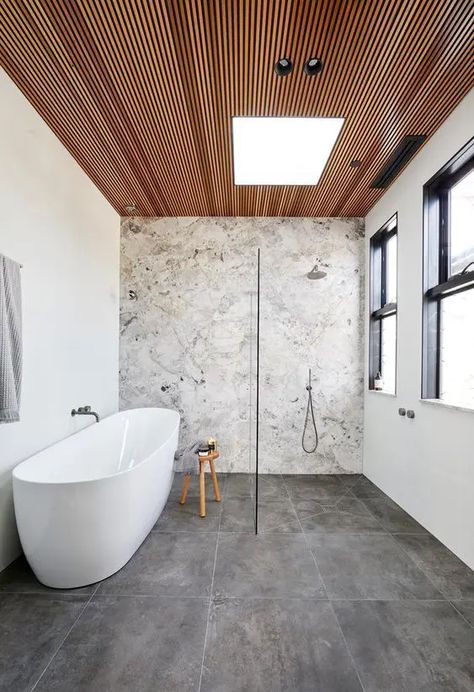 a contemporary bathroom with a stone accent wall, concrete tiles, a wood slab ceiling, neutral fixtures is chic Beautiful Tile Bathroom, Stone Feature Wall, Top Bathroom Design, Timber Ceiling, Wooden Ceiling, Bad Inspiration, Bathroom Modern, Tile Trends, Stone Walls