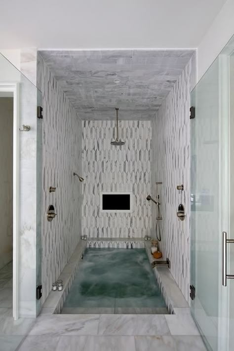 Stunning spa shower boasts white and gray marble tiles and ceiling fitted with a built in TV and a circular rain shower head and sprayer aimed over a sunken bathtub with steps leading out through double glass doors to white marble floors. Sunken Bathtub, Spa Room Ideas, Sunken Tub, White Marble Floor, Spa Rooms, Spa Shower, Bathroom Tub, Tub Shower Combo, Dream Bathrooms