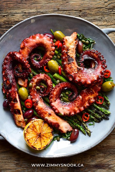 A round dish with coils of grilled octopus with grilled asparagus, wilted spinach & kale, warm olives, served with a lemon-butter, garlic, caper, parsley sauce. Warm Olives, Parsley Sauce, Octopus Recipes, Wilted Spinach, Grilled Octopus, New Year's Eve Recipes, Grilled Asparagus, Lemon Butter, Yummy Eats