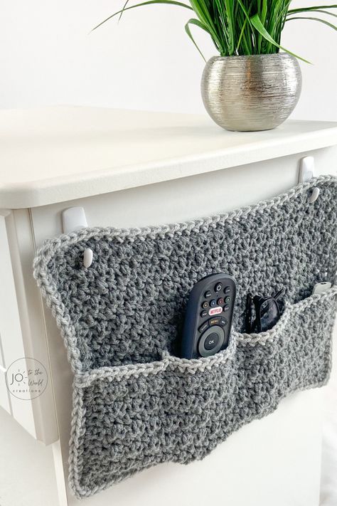 Running out of space on your night table? This easy, fast, free pattern (perfect for beginners) for a hanging remote caddy is a terrific storage idea. This organizer will hold your glasses, phones, pens, notepads and TV remote controls and keep your room organized and decluttered! And it makes a terrific crochet gift idea for men, women and friends.   For more crochet gift ideas, follow me! Crochet Gift Ideas, Crochet Organizer, Remote Holder, Remote Control Holder, Crochet Storage, Quick Crochet Patterns, Diy Magazine, Crochet Gift, Easy Stitch