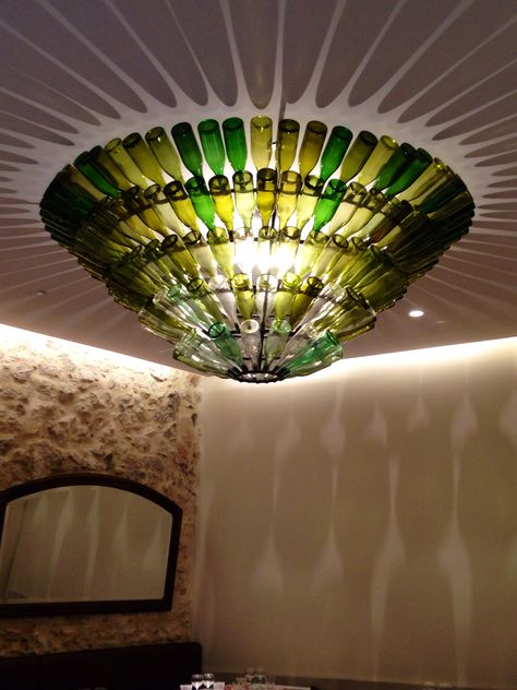 Diy Wine Bottle Chandelier, Water Bottle Chandelier Diy, Hanging Bottle Lights, Wine Bottle Chandelier, Outdoor Restaurant Patio, Chandelier Restaurant, Bottle Chandelier, Exhibition Display Design, Wall Chandelier