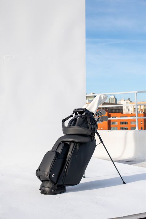 Black golf stand bag on a rooftop with part of a city skyline Golf Stand Bags, Pebble Grey, The Player, Black Pebbles, Golf Accessories, The Next Generation, Next Generation, Golf Bags, The Next