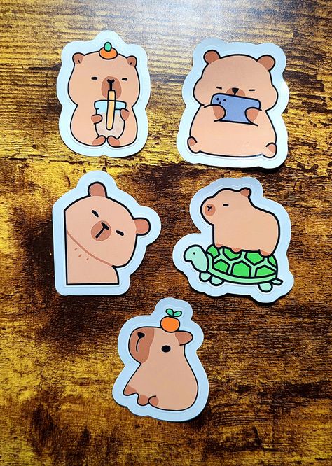 Say hello to the chillest animals around with these cute capybara die-cut stickers! 🐾✨ Each design captures the lovable and laid-back vibes of everyone's favorite furry friends. Perfect for decorating your journal, laptop, water bottle, or planner, these stickers bring a touch of whimsy and fun to your day. ✨ Features:     Easy Peel Edges: Effortless to use - no fiddling required!     High-Quality Material: Durable, water-resistant, and built to last.     Adorable and Relaxed Designs: Featuring capybaras in sweet and playful poses that will steal your heart.     Versatile Use: Great for scrapbooking, gift-wrapping, or personalizing your belongings. 🎁 Perfect for:     Capybara fans and animal lovers     Unique and thoughtful gifts     Adding a quirky touch to your creative projects Each s Playful Poses, Cute Capybara, Cut Stickers, Die Cut Stickers, Animal Lovers, Creative Projects, Say Hello, Sticker Paper, Thoughtful Gifts