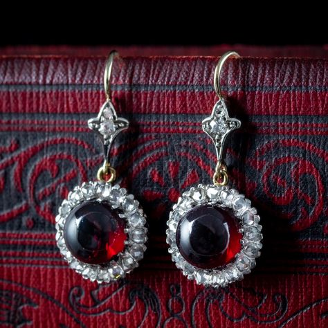 New in! 🌹 A gorgeous pair of antique Edwardian garnet diamond drop earrings adorned with a pretty daisy-shaped gallery at the bottom, adorned with a blazing red cabochon garnet in the centre (approx. 2.5ct each), haloed by twinkling rose-cut diamond petals and two more on the hooks above (approx. 2ct total). The earrings are a union of 15ct yellow and white gold and feature pierced metalwork around the sides and hook wires on top. They’re a striking antique pair and the combination of dark ... Edwardian Engagement Ring, Crimson Red, Garnet Earrings, Memento Mori, Antique Jewellery, Rose Cut Diamond, Diamond Drop Earrings, Rose Cut, Metal Working