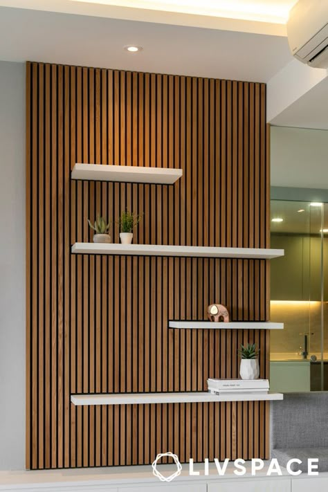 wooden-panel-design-that-also-works-as-display-unit Wood Paneling With Shelves, Wood Accent Walls Living Room, Vertical Wood Slat Wall With Shelves, Wood Slat Accent Wall With Shelves, Vertical Slat Wall Interiors, Wall Panelling Bathroom Ideas, Wood Panel Wall With Shelves, Wood Slat Gallery Wall, Slat Wall Wainscoting