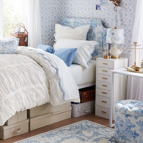 Add an enchanting feel to your space with this blue wallpaper, featuring a charming floral and lattice bow pattern. A peel-and-stick backing makes it simple to hang, and it has a convenient wipe-clean finish. Designed exclusively for Pottery Barn Teen by lifestyle brand LoveShackFancy. Made of digitally printed, non-woven wallcovering reinforced with synthetic fibers for strength and durability. Microsphere adhesive with removable paper backing. Adhesive is water activated. This is a one-time pe Blue Preppy Bedroom Ideas, Blue Love Shack Fancy Bedroom, Blue Floral Dorm Room, Cute Bedroom Ideas Blue, Love Shack Fancy Dorm, Beach Bedroom Ideas For Teens, Blue Preppy Bedroom, Room Ideas Navy Blue, Pink And Blue Dorm