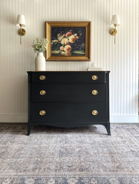 *DRESSER AVAILABLE!* This Hepplewhite antique dresser has a delightful energy and a modern organic essence! If you love more transitional or a mix of styles in your home while keeping a traditional undertone then this vintage dresser is for you! This chest of drawers has it all - a smooth matte black exterior, the quintessential Hepplewhite oval brassy gold pulls on each drawer and offers plenty of storage. What makes this dresser stand out is like something from a country farmhouse or an RH catalogue is the naturally gorgeous driftwood/primitive raw wood top.  A dark wax was added to the raw wood top to seal for durability, add a weathered look and be able to be a piece or table top in a high traffic area. Use this piece in a bedroom as a dresser, as a nursery dresser/chest, an entryway c Black Dresser Gold Mirror, Black Furniture Decor Ideas, Dark Brown Painted Dresser, Antique Commode Makeover, Antique Black Dresser, Antique Refurbished Furniture, Matte Black Dresser, Decorated Dresser Top, Black Dresser Nursery