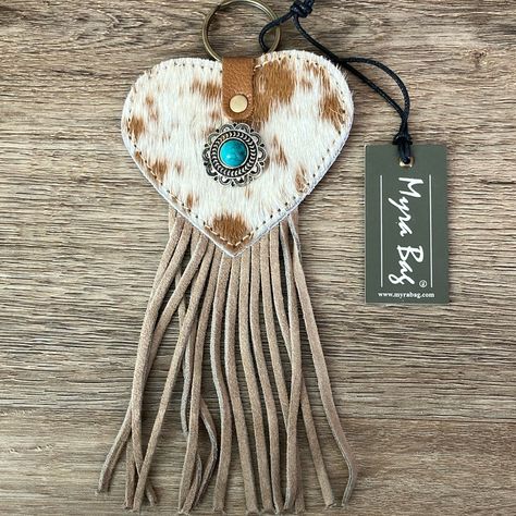 Nwt Myra Bag “Enduring Love” Heart Shaped Key Fob. Brown And White Hair On Hide. Silver Tone Antiqued Concho Medallion With Lab Created Turquoise Stone. Flow Of Sandstone-Colored Leather Suede Fringe Underneath. Materials: Hair On Hide And Leather. 3.5”W X 7.5”H (Includes Fringe). S-7550. Note That My Pictures Are The Exact Product Listed And The One You’ll Receive. Nwt New With Tag. Smoke Free Home. Bundle And Save! Offers Welcome! Nwt And Euc Jeans, Denim Jackets, Activewear And More Added To Diy Boho Purse, Western Keychain Ideas, Cowhide Projects, Cowhide Diy, Brown And White Hair, Leather Horse Tack, Cowhide Decor, Cowboy Crafts, Stocking Stuffers For Mom