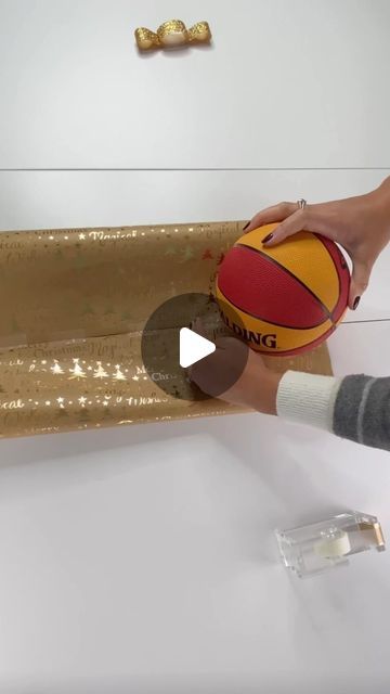 Football Gift Wrapping Ideas, Ball Wrapping Gift, Wrap A Ball With Paper, How To Wrap A Ball Present, How To Wrap A Baseball Bat As A Gift, Wrapping A Ball Gift, How To Wrap An Ornament As A Gift, How To Gift Wrap A Ball, How To Wrap A Tube Shaped Gift