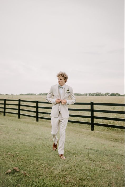 Groom is wearing mens wear house suit in tan, with sage green bow tie and brown shoes. Tan And Green Tuxedo Wedding, Tan Suit Wedding Sage Green, Tan Suit With Sage Green Tie, Tan Suite Sage Tie, Tan Suit With Green Tie, Tan Suit With Green Bow Tie, Tan Suit Green Tie, Champagne Tux, Tan Tux