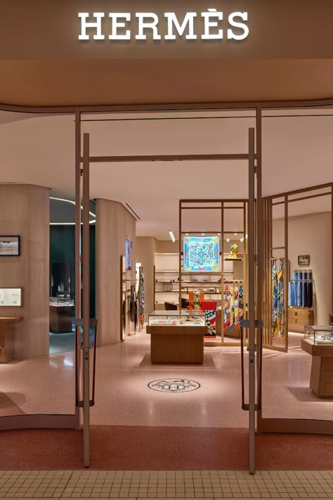 The new Hermès store at Aventura Mall fuses Miami’s unique coastal atmosphere with the luxury fashion house’s French spirit. Customers enter the store through an undulating glass façade, reminiscent of the waves of the sea and framed in metal in a warm shade of pink. Across the threshold, discover all 20 product categories such as leather goods, fine silk scarves, ties, men and women’s ready-to-wear collections, jewelry, fragrance, Art de Vivre, and Art de Table. Visit Hermès at Aventura Mall. Aventura Mall, Hermes Store, Hermes Shop, Mall Stores, Dark Green Aesthetic, Store Layout, Store Interiors, Store Design Interior, Store Interior