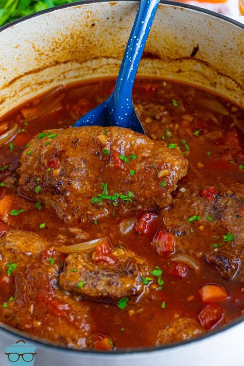 A serving spoon in a Dutch Oven with Swiss Steak. Dutch Oven Main Dish Recipes, Oven Baked Swiss Steak, Old Fashioned Swiss Steak, Best Swiss Steak Recipes, Dutch Oven Ribs In Oven, Swiss Steak Recipes Skillet, Oven Cube Steak, Swiss Steak Recipes Crockpot, Swiss Steak Recipes Oven