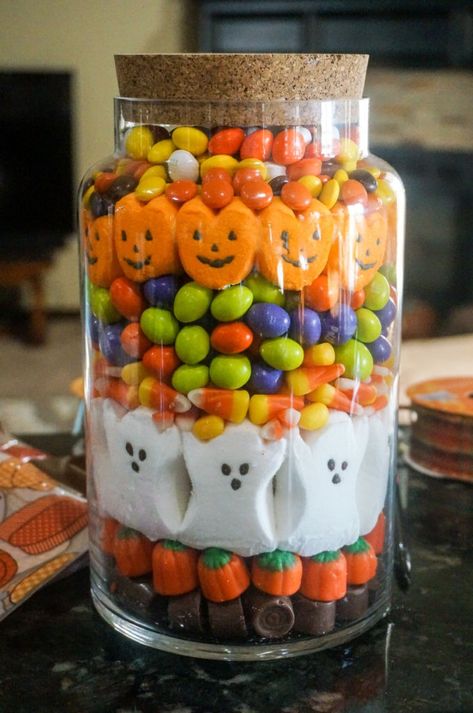 A Halloween Candy Jar is a unique way to decorate for the spooky holiday using all your favorite pretty, colorful candies. There are so many interesting types of candy at Halloween so it's the perfect time of year to use your creativity to make this candy jar. | Fall Candy Jar | Halloween Candy Decor | Decorating with Candy | Halloween Home Decor | #Halloween #Fall #Candy #CandyCorn #Peeps Halloween Candy Crafts For Adults, Halloween Candy Jars Gift Ideas, Halloween Candy Centerpiece, Halloween Candy Jars Diy, Halloween Candy Basket Ideas, Halloween Candy Jars Ideas, Fall Candy Jar Ideas, Candy Jars Ideas, Halloween Candy Decorations